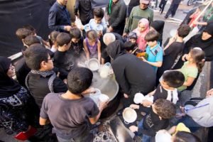 People pressing in around a food and drink distribution point