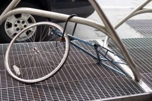 An upturned bicycle resting on a metal grate